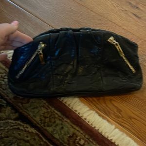 This is a black Tory Burch clutch. It comes with a detachable mirror.